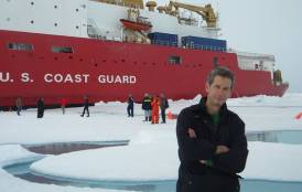Kevin Arrigo standing in front of a U.S coast guard ship