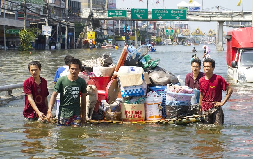 People transporting items over a flooded street
